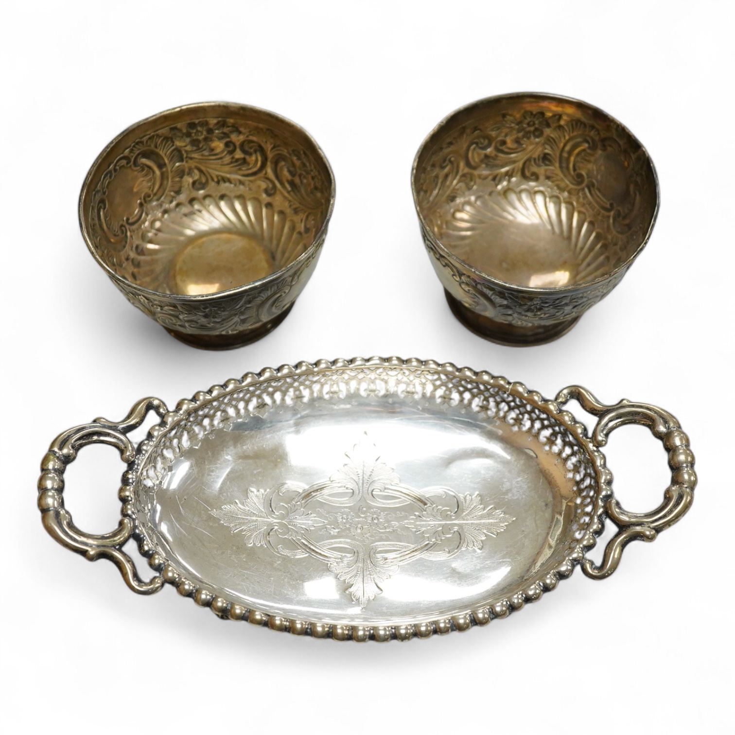 A pair of Edwardian repousse silver pedestal bowls, by Charles Boyton & Son Ltd, London, 1906, diameter 11.4cm(a.f.), 6.9oz and a plated two handled dish.